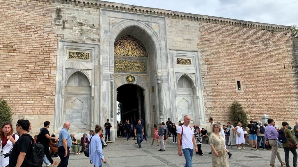 Istanbul Gulhane Park Entrance also takes you to the Topkapi Palace, shows people in t-shirts and shorts as it's quite hot in October.